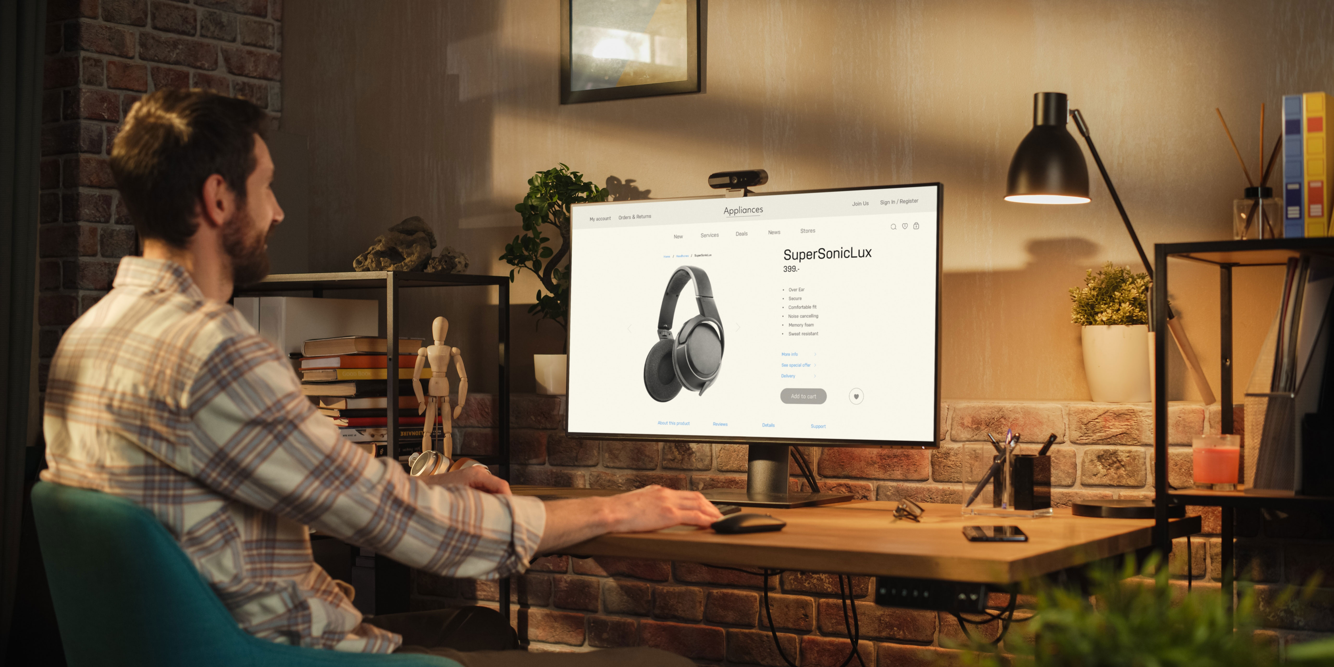 A desktop computer in a dimly-lit home office being used by a man sitting in chair.